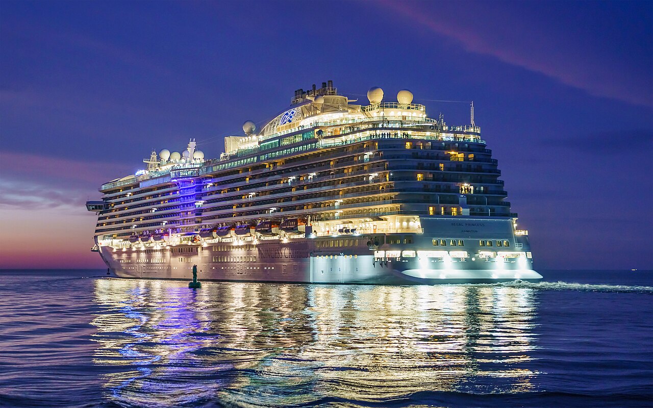 Regal Princess illuminated at dusk near Warnemünde port in Rostock, Germany